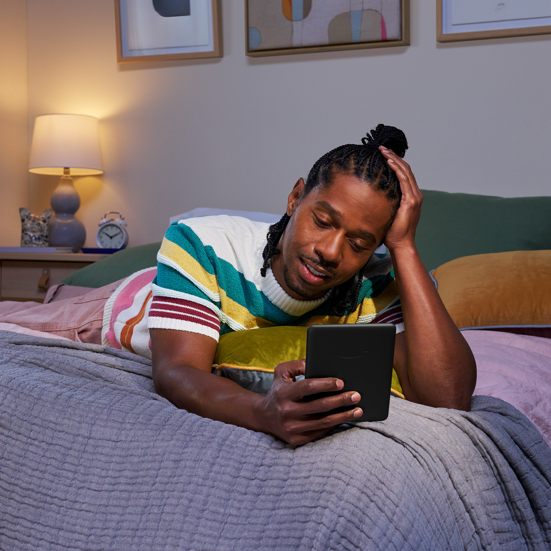 Um homem está na cama enquanto lê seu Kindle Paperwhite Signature Edition.